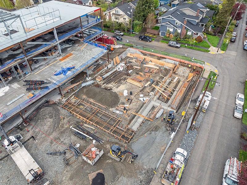 concrete footings and wood frames next to a building under construction